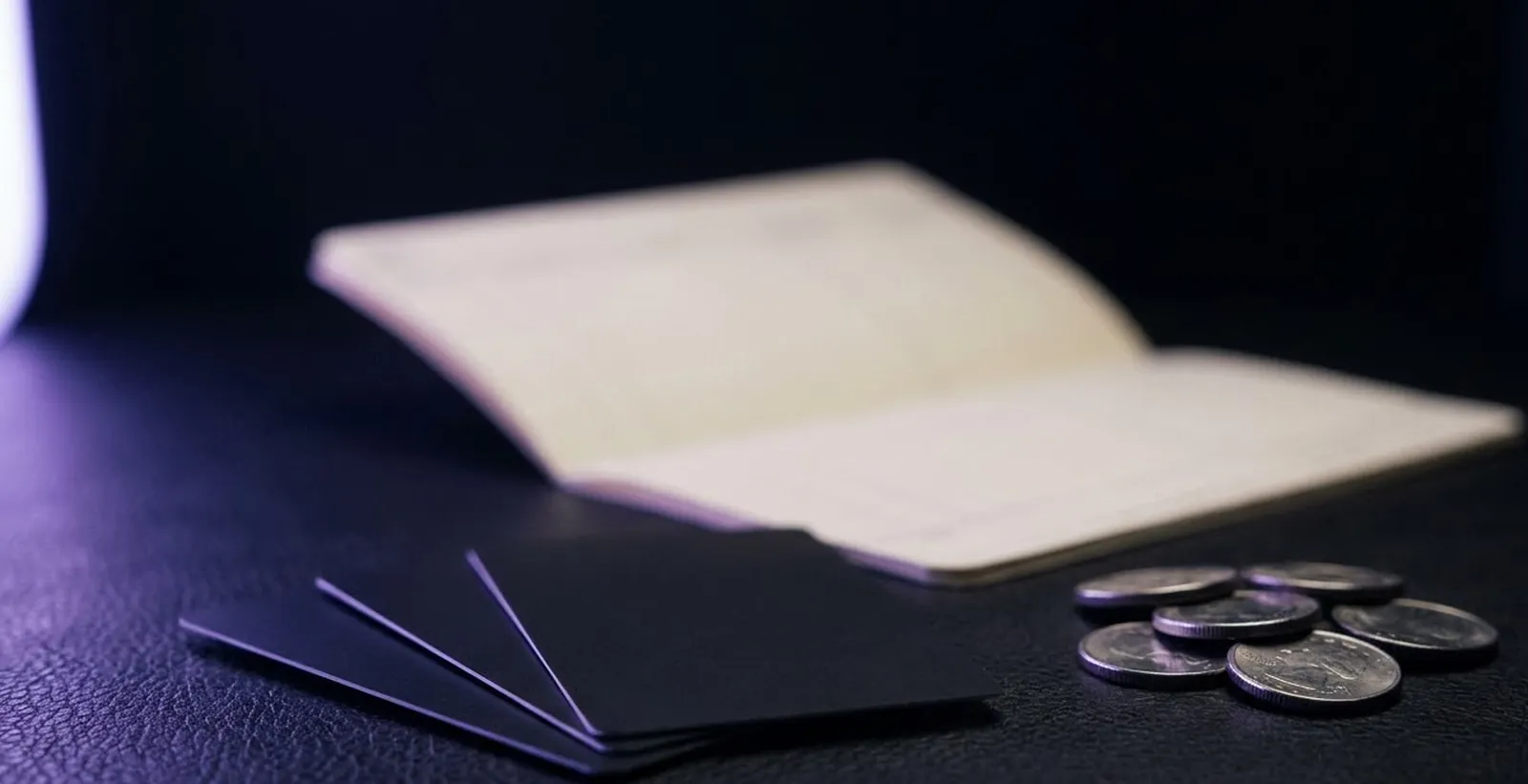 Cards, coins and a paper ledger on dark leather